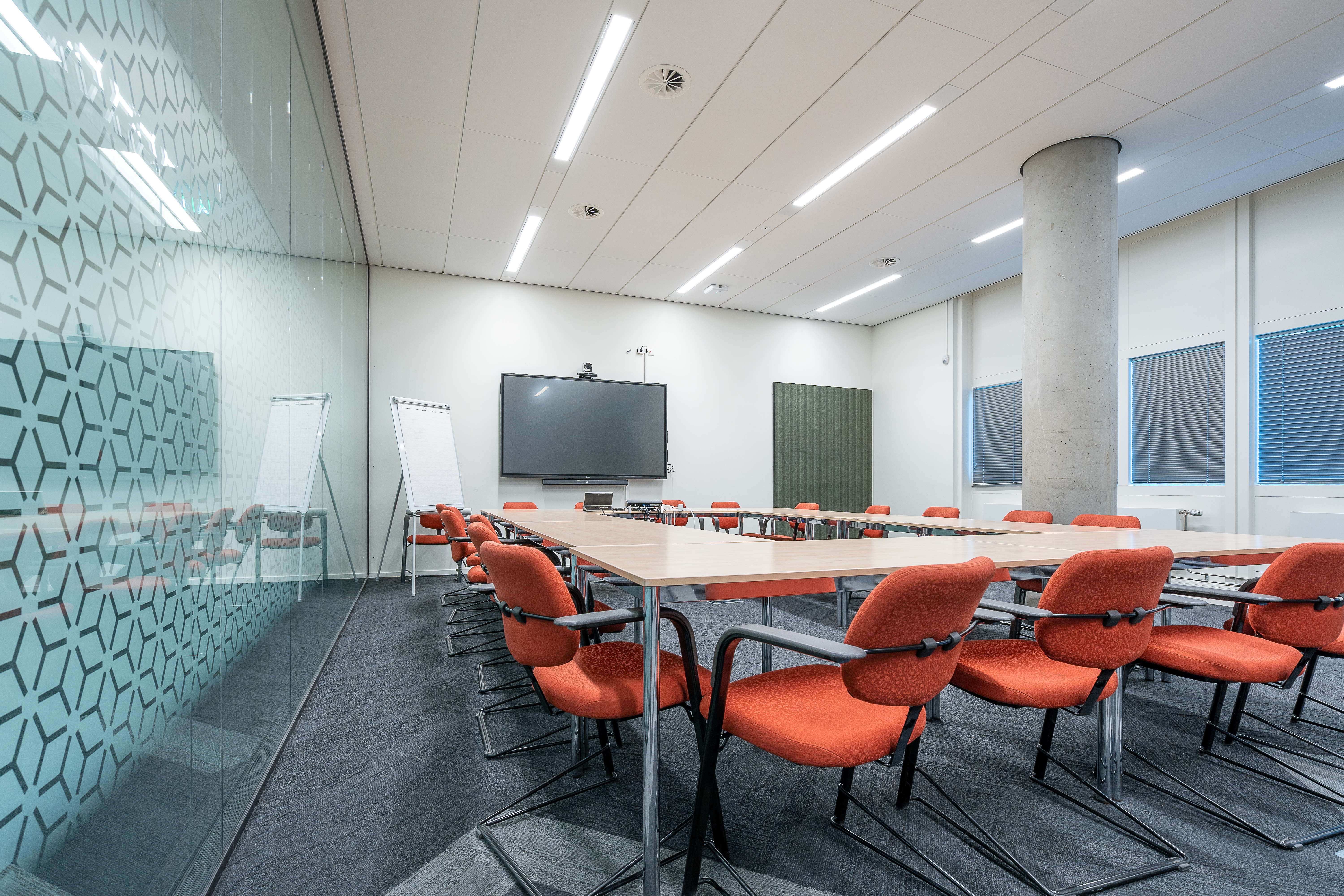 conference room interior of a modern office with white walls and a monitor